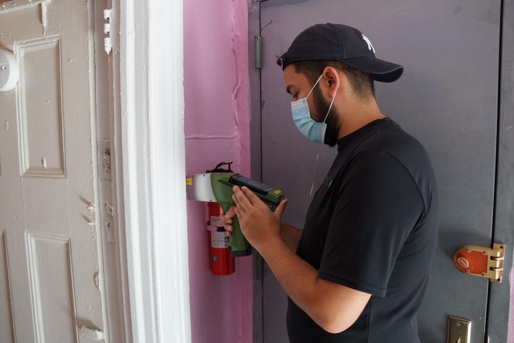 A Green Orchard Group employee uses XRF technology to test walls in an apartment for lead paint. 