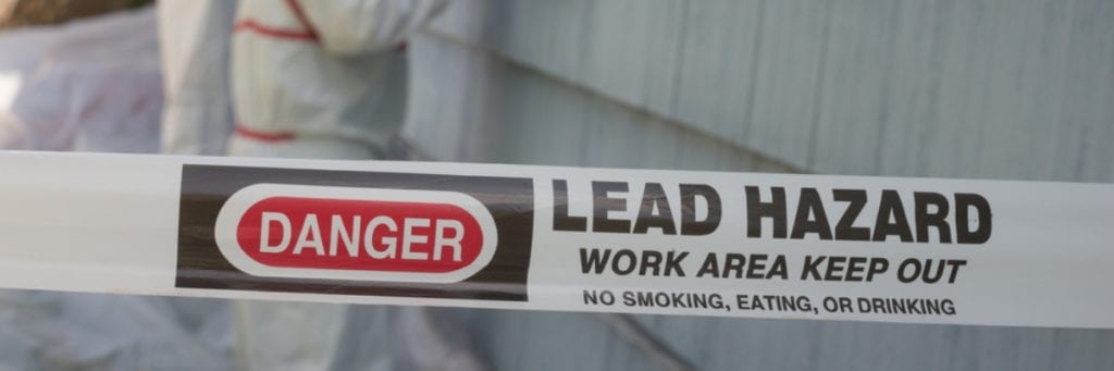 A sign reads "Lead Hazard work area: Keep out; no smoking, eating, or drinking".