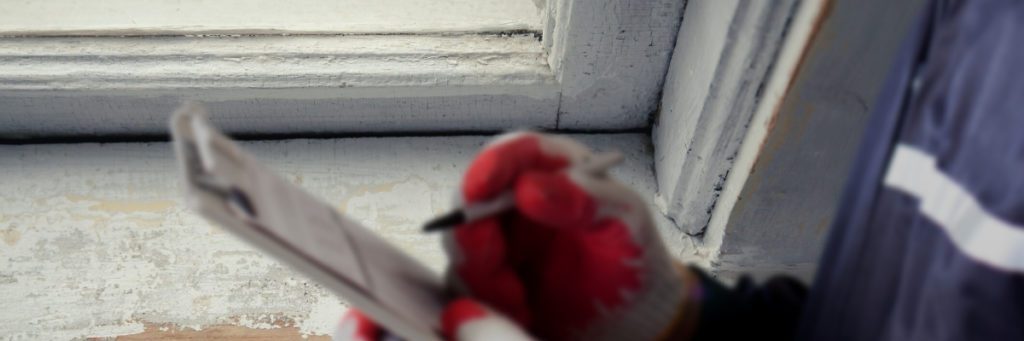 An inspector examines a windowsill for lead paint. 